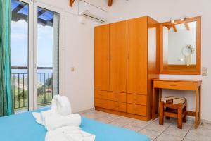 a bedroom with a bed and a desk and a mirror at VILLA MITZELOS in Skiathos
