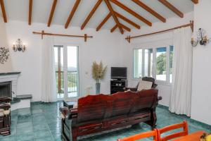 a living room with a couch and a television at VILLA MITZELOS in Skiathos
