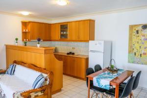a kitchen with a bed and a table and a refrigerator at VILLA MITZELOS in Skiathos