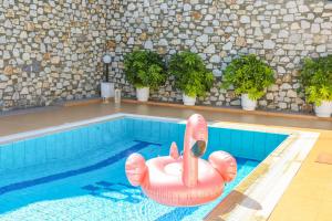 a swimming pool with an inflatablelatable elephant in the water at VILLA MITZELOS in Skiathos