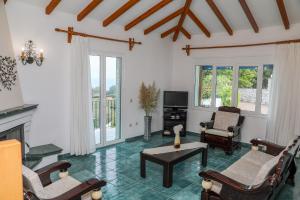 a living room filled with furniture and a fireplace at VILLA MITZELOS in Skiathos