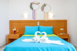 a bed with two towels in the shape of a heart at VILLA MITZELOS in Skiathos