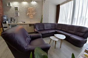a living room with a leather couch and a table at Pension Happy Day - motorcycle friendly in Sibiu
