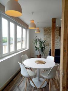una sala da pranzo con tavolo bianco e sedie bianche di Neuf, 50m2, 4m50 de loggia ad Auch