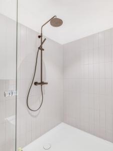 a shower with a shower head in a bathroom at limehome Augsburg Annastraße in Augsburg