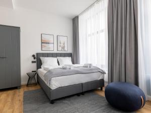 a bedroom with a bed and a blue ottoman at Limehome Augsburg Annastraße in Augsburg