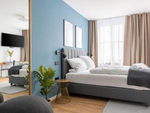 a bedroom with blue walls and a bed with a mirror at Limehome Augsburg Annastraße in Augsburg