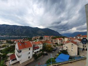 una ciudad con edificios y una montaña en el fondo en BLUE EYES SAILORS, en Kotor