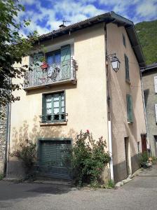 um edifício com uma varanda e uma janela em La maison des vacances em Auzat