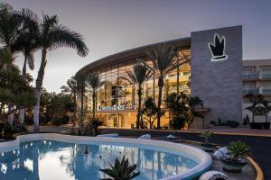 un hôtel avec une piscine en face d'un bâtiment dans l'établissement Tabaiba Princess, à Maspalomas