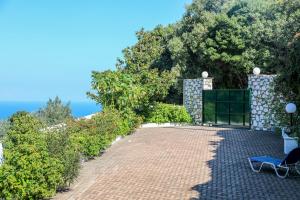 a brick driveway with a chair on the side of a house at VILLA MITZELOS in Skiathos