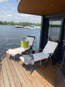 dos sillas y un banco en la cubierta de un barco en Schwimmende Ferienwohnung, Hausboot Urlaub als Festlieger am Steg, en Zehdenick