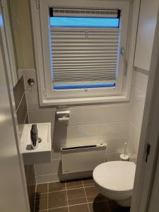 a small bathroom with a toilet and a window at Schwimmende Ferienwohnung, Hausboot Urlaub als Festlieger am Steg in Zehdenick