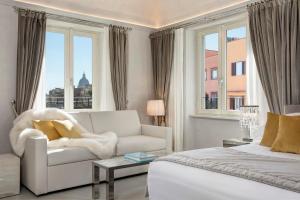 een witte woonkamer met een bank en een raam bij Palazzo Nainer in Rome