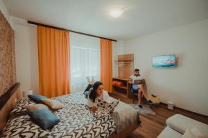 a woman laying on a bed in a hotel room at Apartman Lovrić Đakovo in Đakovo