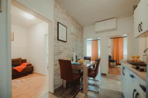 a kitchen and living room with a table and chairs at Apartman Lovrić Đakovo in Đakovo