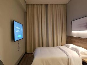 Televiisor ja/või meelelahutuskeskus majutusasutuses Unijoy Cityinn OCT Loft Shenzhen有集城市客栈创意园店