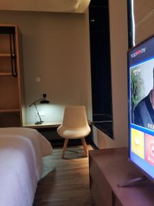 Televiisor ja/või meelelahutuskeskus majutusasutuses Unijoy Cityinn OCT Loft Shenzhen有集城市客栈创意园店