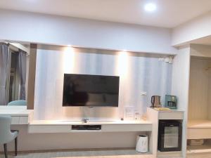 a living room with a flat screen tv on a wall at SUN 9 Inn in Hengchun South Gate