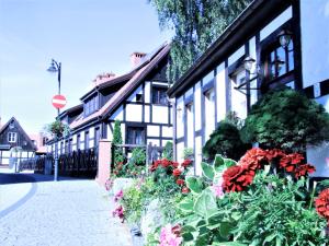 een gebouw met bloemen aan de straatkant bij Apartamenty Royal Maris 4 - najlepsza lokalizacja w Ustce, blisko plaży i portu, bezpłatny parking, ścicsłe centrum in Ustka