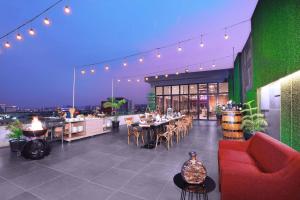 a restaurant with tables and chairs on a rooftop at ASTON Inn Pandanaran in Semarang