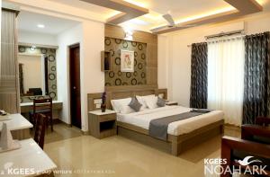 a hotel room with a bed and a desk at Kgees Noah Ark in Thodupuzha