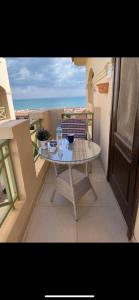 a table on a balcony with a view of the ocean at Cozy chalet in a luxurious compound family only in Ain Sokhna