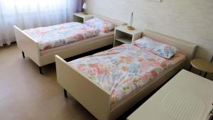 two beds sitting in a room with a table at Comfortable apartment for 2 Persons in Hannover