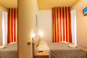 um pequeno quarto com duas camas e cortinas em Activ Hotel Salsedine em Rimini