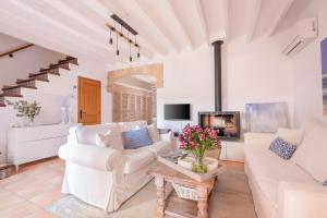 a living room with white furniture and a fireplace at Townhouse Can Neri by SunVillas Mallorca in Pollença