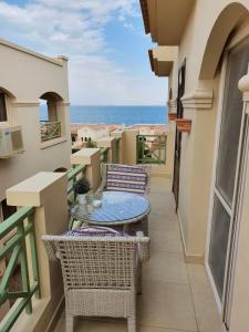 a balcony with tables and chairs and the ocean at Cozy chalet in a luxurious compound family only in Ain Sokhna