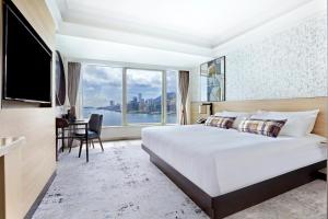 ein Schlafzimmer mit großem Bett und großem Fenster in der Unterkunft Harbour Grand Kowloon in Hongkong