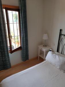 een slaapkamer met een wit bed en een raam bij Bravo 24 in Fuengirola