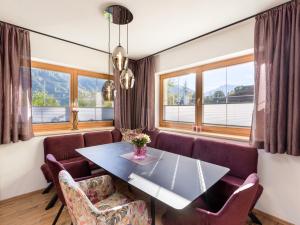 comedor con mesa, sillas y ventanas en Apartment Katharina, en Brandberg