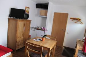 a small room with a small table and a television at Gästehaus Ballmann in Rockeskyll