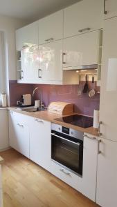 a kitchen with white cabinets and a stove top oven at Blick über Krems mit Gartenpavillon in Krems an der Donau