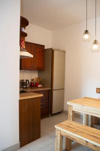 uma cozinha com uma mesa de madeira e um frigorífico em Apartament na stoku em Szczyrk