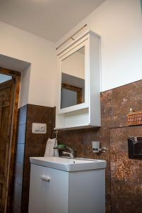 uma casa de banho com um lavatório branco e um espelho. em Apartament na stoku em Szczyrk