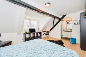 an attic bedroom with a bed and a desk at B&B De Smederij in Amerongen