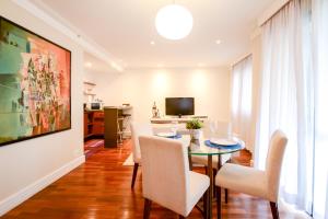 a dining room with a table and chairs and a television at Flat Clarity Apartments by BnbHost in São Paulo