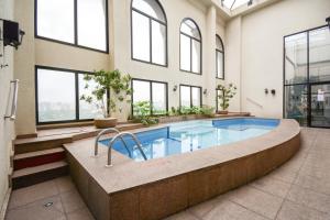 a large swimming pool in a building with windows at Flat Clarity Apartments by BnbHost in São Paulo