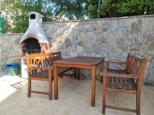 a wooden table and two chairs and a brick oven at Apartments Gorica 1 in Baška