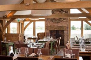 a restaurant with tables and chairs and a fireplace at The Pig Inn in Snaith