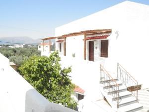 a white house with stairs on the side of it at Aeolos Hotel Apartments in Gythio