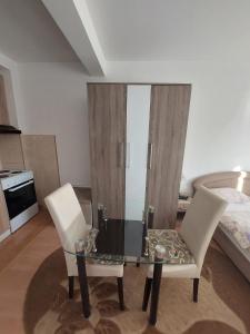 1 mesa y 2 sillas en una habitación con 1 cama en Renome apartmani, en Banja Koviljača