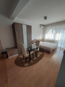 ein Schlafzimmer mit einem Tisch, Stühlen und einem Bett in der Unterkunft Renome apartmani in Banja Koviljača