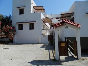 a white building with a gate in front of it at Aeolos Hotel Apartments in Gythio