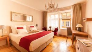 a hotel room with a bed, desk, chair, lamp and window at Hotel Golden Key Prague Castle in Prague
