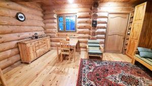 ein Zimmer mit Tisch und Stühlen in einer Blockhütte in der Unterkunft Wild Hog Guesthouse in Grūži