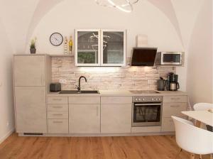 Biała kuchnia ze zlewem i kuchenką w obiekcie Appartementhaus Angelika w mieście Lindau